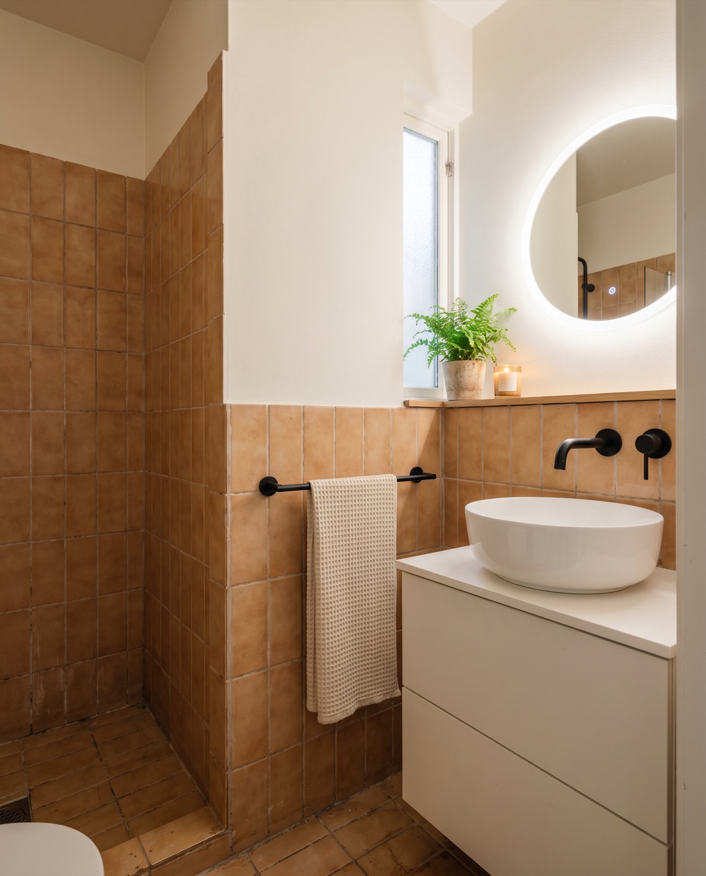 Refreshed bathroom with new paint, a new illuminated mirror and new taps, same tiles as before